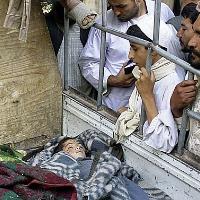 Relatives look at children killed by a 2009 U.S. airstrike in Kandahar Afghanistan