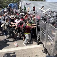 Immigrants seeking asylum in U.S. confront National Guard at border.