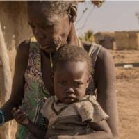 A mother giving sorghum porridge to her children. A growing number of children in South Sudan’s Northern Bahr el Ghazal and Warrap have only one meal per day.