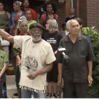 Omali Yeshitela, leader of the African People's Socialist Party, points to damage done in the FBI raid on his home.