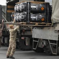 Ukrainian servicemen load weaponry from the U.S. into trucks.