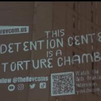 Projection on prison wall: This detention center is a torture chamber