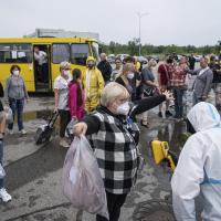 Ukrainian emergency workers wearing radiation protection suits check the radiation level of passengers of a bus in a drill near the Zaporizhzhia nuclear plant in Ukraine