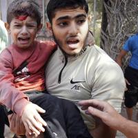 A wounded boy is carried after an Israeli strike in Deir Al-Balah, southern Gaza Strip, November 9, 2023.