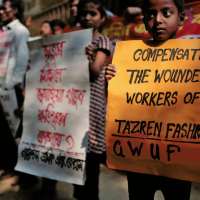 Relatives of victims of the Tazreen factory fire demonstrate, November 24, 2014. The center sign reads, “Sumaya Khatun, a victim of Tazreen Fashions fire—where is compensation?”