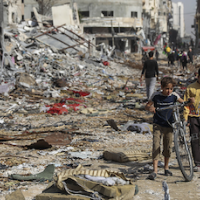 Palestinian children with bikes surrounded by the rubble of Gaza City during ceasefire, November 24, 2023.
