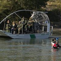 Migrants crossing the Rio Grande at Eagle Pass, Texas, are watched by border patrol agents, January 3, 2024.