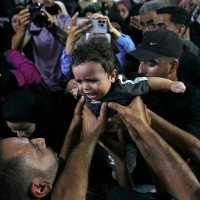 Mourners carry six-month-old orphan in Nablus, August 15, 2024.