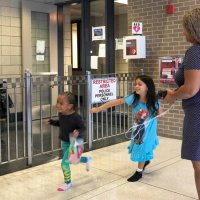An immigrant from Venezuela plays with her children. They are living in the Chicago Police Department’s 16th District station, May 1, 2023.
