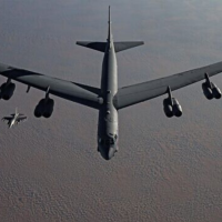B-52 heavy bomber, flanked by fighter jets