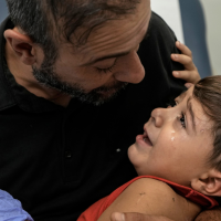 A father consoles his four-year-old, wounded by an Israeli airstrike on a densely-populated neighborhood south of Beirut, November 5, 2024.