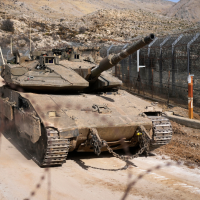 Israeli tank maneuvers next to the security fence that separates the Israeli-annexed Golan Heights from Syria, December 11, 2024.