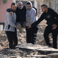 Palestinians evacuate from the Jenin refugee camp in the West Bank carrying an elderly man over rubble, January 23, 2025.