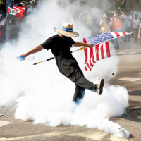 A demonstrator kicks a canister of tear gas during a Los Angeles protest, June 14, 2025.