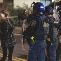 A protester is sprayed by a Department of Homeland Security officer outside the Portland ICE facility, October 2, 2025.