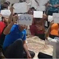 Prisoners occupy corridor at Ghezel Hesar Prison, holding signs that read “Sentenced to Death” and “No to Executions.”