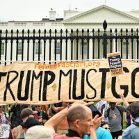 Refuse Fascism banner "Trump Must Go Now" in front of the White House gates.
