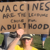 Protest sign: Vaccines are the leading cause for adulthood