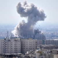 A plume of smoke rises after a strike in Tehran, Iran, March 1, 2026.