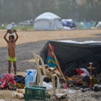 A boy in a makeshift shower after fleeing Israeli bombardment of his village in southern Lebanon, April 3, 2026.