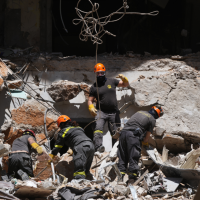 Lebanese workers search through rubble from Israeli airstrike for the body of missing student, April 11, 2026.
