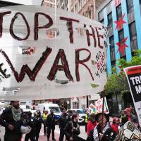 Banner Stop the War and sign Trump Must Go Now at May Day rally in Chicago, May 1, 2026.