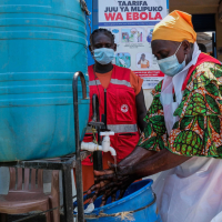 A health worker washes her hands at a temporary health clinic at a border crossing between Uganda and the Democratic Republic of the Congo, June 4, 2026.